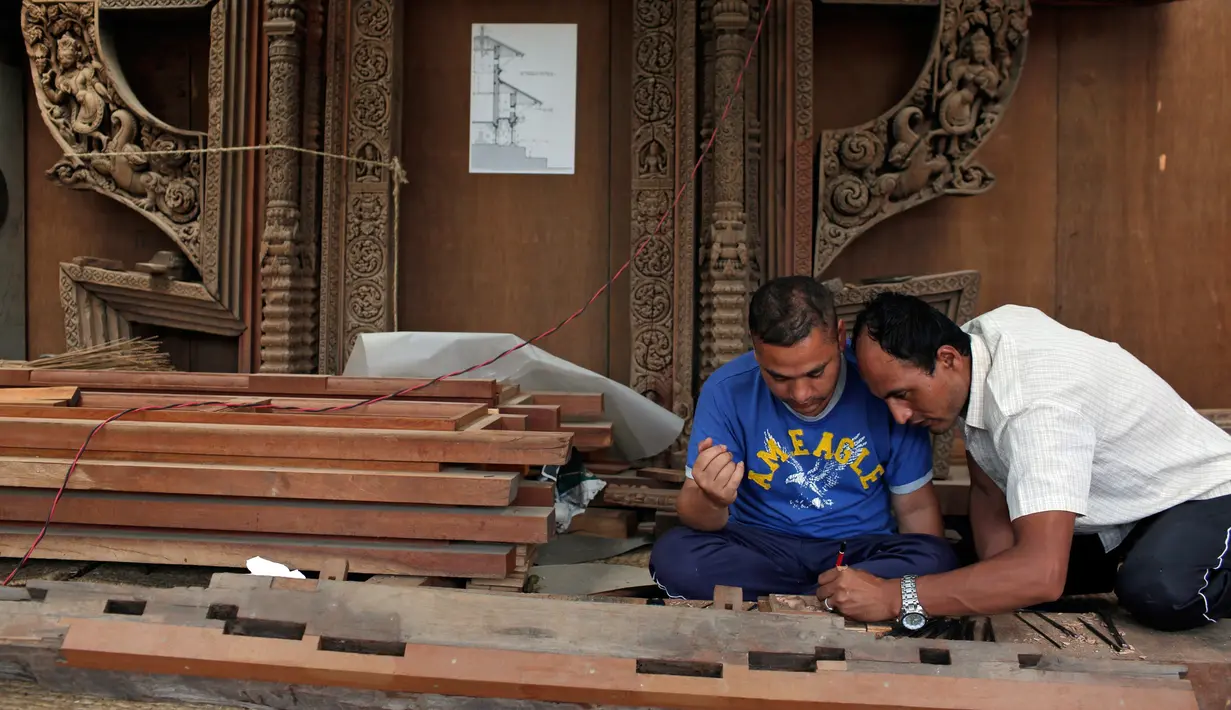 Pengrajin kayu membuat sketsa diatas kayu sebelum diukir di Lalitput, Nepal (19/7). (AP Photo/Niranjan Shrestha)