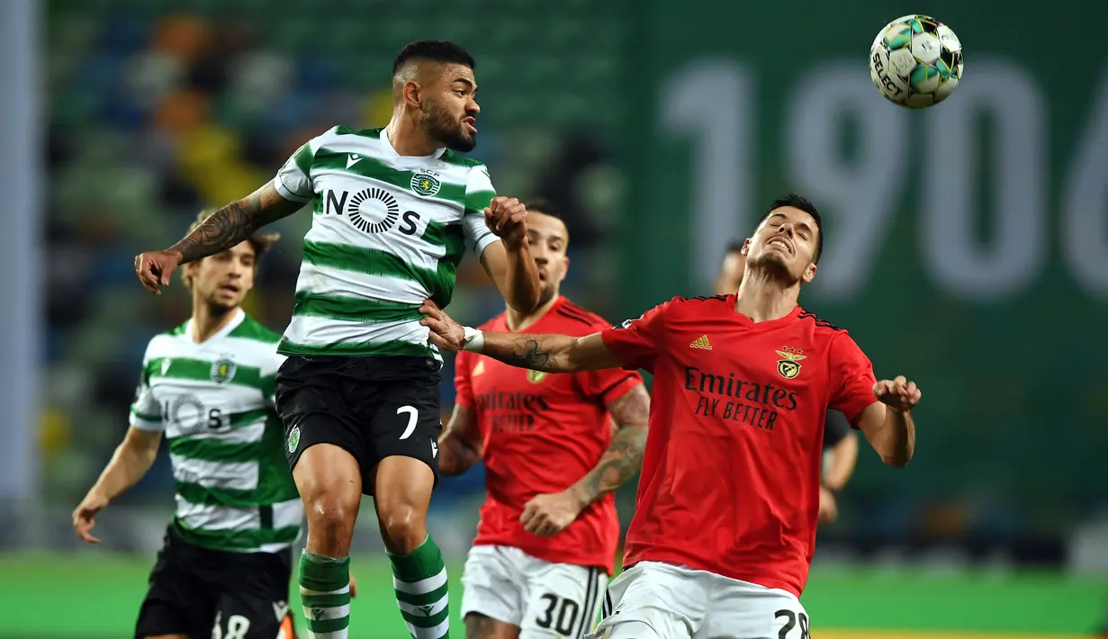 Gelandang Sporting Lisbon, Rafael Camacho (kiri) menyundul bola dibayangi gelandang Benfica, Julian Weigl dalam laga lanjutan Liga Portugal 2020/21 di Jose Avalade Stadium, Lisbon, Senin (1/2/20201). Sporting menang 1-0 atas Benfica. (AFP/Patricia De Melo Moreira)