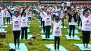 Ratusan warga melakukan gerakan yoga saat mengikuti sesi yoga massal di Stadion Afraha di Nakuru, Kenya (15/6/2019). Acara yoga massal ini untuk memperingati Hari Yoga Internasional. (AFP Photo/Suleiman Mbatiah)