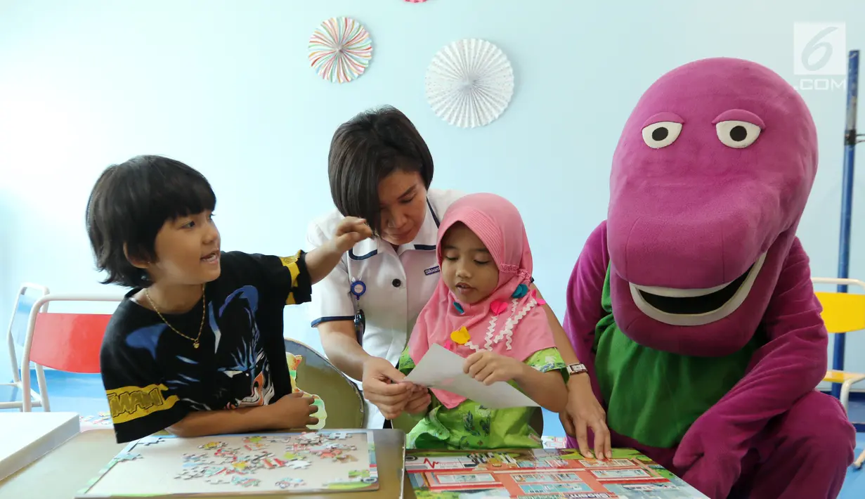 Perawat dan karakter Boneka Barney membimbing anak-anak bermain puzzle jelang peringati Hari Anak Nasional yang jatuh pada 23 Juli 2017 di RS Siloam Asri, Jakarta, Sabtu (22/07). (Liputan6.com/Fery Pradolo)