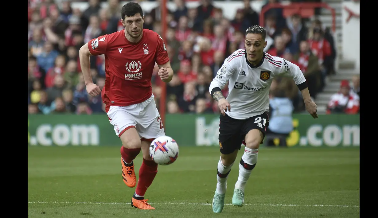 Pemain Manchester United, Antony (kanan) mengejar bola dibayangi pemain Nottingham Forest, Scott McKenna saat laga pekan ke-31 Liga Inggris 2022/2023 di City Ground, Nottingham, Senin (17/04/2023) dini hari WIB. Setan Merah berhasil menang dengan skor 2-0. (AP Photo/Rui Vieira)