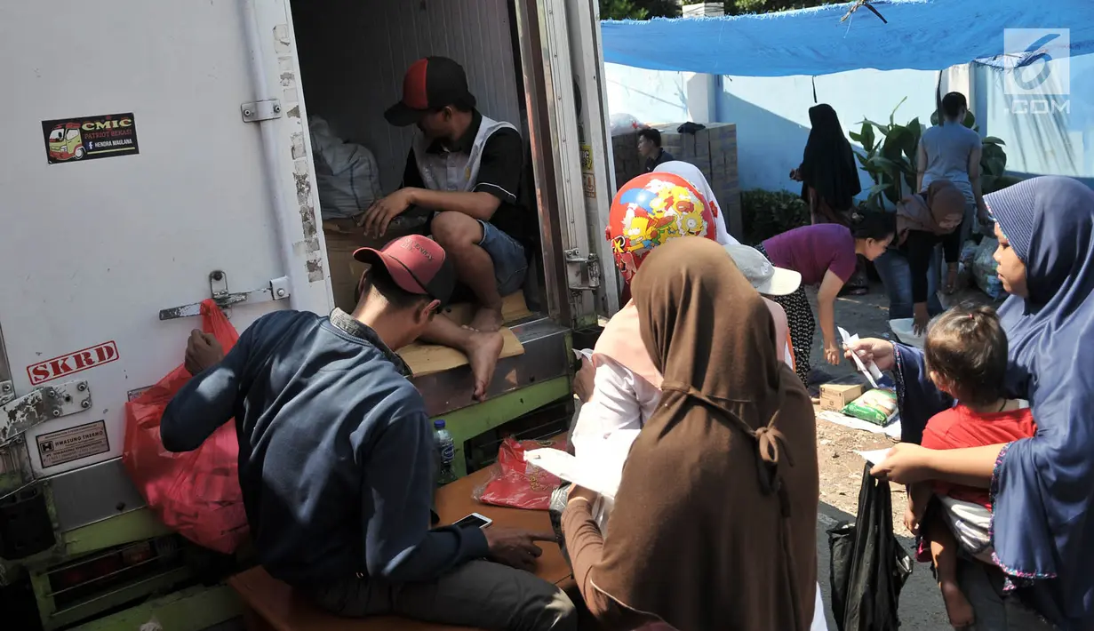 Warga membeli kebutuhan pokok menggunakan KJP saat berlangsungnya Program Pangan Murah di RPTRA Utakara Beriman, Jakarta, Kamis (20/6/2019). Kebutuhan Pokok dalam Program Pangan Murah tersebut terdiri atas beras, telur, daging sapi, daging ayam, ikan, dan susu. (merdeka.com/Iqbal S Nugroho)