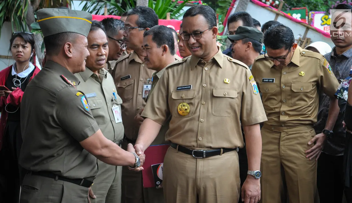 Gubernur dan Wakil Gubernur baru DKI, Anies Baswedan dan Sandiaga Uno setibanya di Balai Kota Jakarta, Selasa (17/10). Anies dan Sandiaga keliling Balai Kota sebelum menggelar rapat bersama SKPD DKI Jakarta. (Liputan6.com/Faizal Fanani)