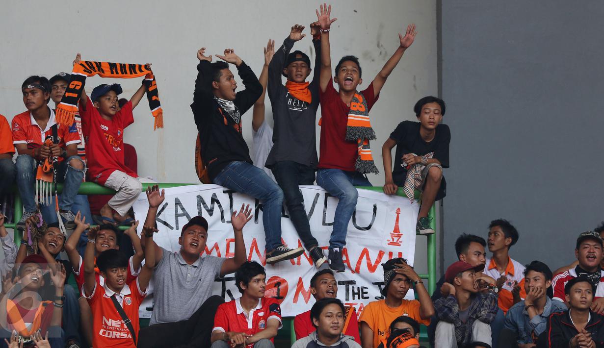 Suporter meneriakkan yel yel saat menyaksikan laga Persija melawan Mitra Kukar pada lanjutan Liga 1 Indonesia di Stadion Patriot Candrabhaga, Bekasi, Minggu (14/5). Laga kedua tim berakhir imbang 1-1. (Liputan6.com/Helmi Fithriansyah)