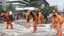 Pasukan oranye membersihkan sisa residu gas air mata dari badan jalan MH Thamrin dekat Gedung Bawaslu, Jakarta, Kamis (23/5/2019). Sebelumnya, aksi unjuk rasa yang dilakukan massa pada Rabu (22/5) berakhir ricuh. (Liputan6.com/Helmi Fithriansyah)