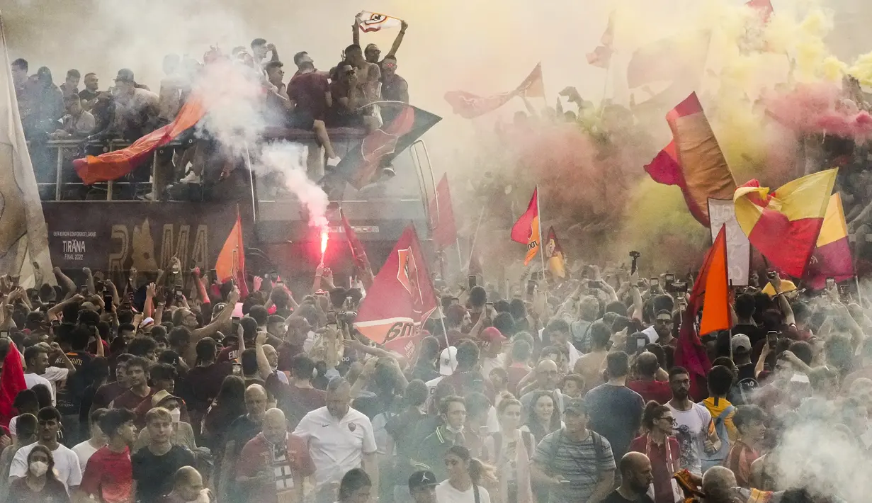 Bus tim AS Roma melaju di tengah kerumunan pendukung yang bergembira saat merayakan kemenangan juara Liga Konferensi Eropa UECL di depan Colosseum di Roma (26/5/2022). AS Roma menjuarai Konferensi Eropa UECL setelah mengalahkan Fayenoord dengan skor tipis 1-0. (AP Photo/Gregorio Borgia)