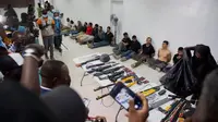Tersangka dalam pembunuhan Presiden Haiti Jovenel Moise, bersama dengan senjata dan peralatan yang diduga mereka gunakan, ditunjukkan kepada media di Port-au-Prince pada 8 Juli 2021 (AP)