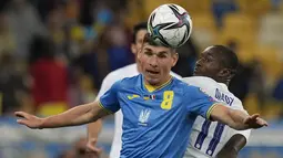 Gelandang timnas Ukraina Ruslan Malinovsyi berebut bola dengan penyerang timnas Prancis, Moussa Diaby dalam laga Kualifikasi Piala Dunia 2022 zona Eropa di NSK Olimpiyskiy, Minggu (5/9/2021) dinihari WIB. Prancis bermain imbang 1-1 dengan tuan rumah, Ukraina. (AP Photo/Efrem Lukatsky)