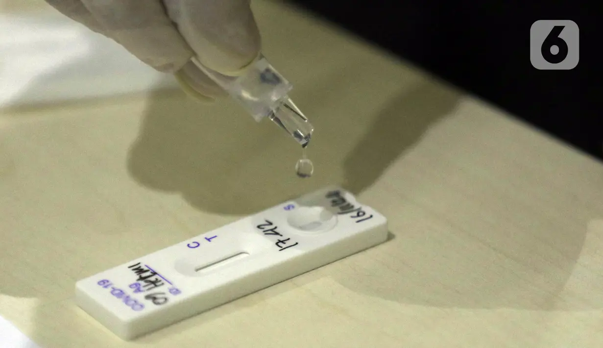 Petugas medis melaksanakan proses rapid test antigen di ruang wartawan Gedung KPK, Jakarta, Senin (16/11/2020). Pada Senin (16/11) siang, ada penambahan kasus positif Covid-19 sebanyak 3.535 dan jumlah pasien sembuh bertambah 3.452 orang. (Liputan6.com/Helmi Fithriansyah)