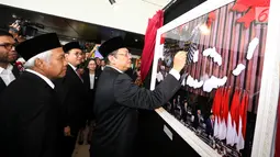 Ketua DPR Bambang Soesatyo menandantangani sebuah foto selama pameran Foto Wartawan Parlemen bertema DPR Zaman Now di Jakarta, Kamis (29/8/2019).  Pameran ini berlangsung 28 Agustus-2 September 2019. (Liputan6.com/Johan Tallo)