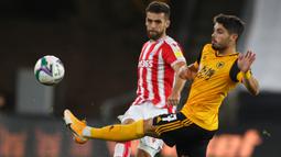 Gelandang Wolves, Pedro Neto, berebut bola dengan bek Stoke City, Tommy Smith, pada laga kompetisi Piala Inggris di Malineaux Stadium, Jumat (18/9/2020) dini hari WIB. Wolves kalah 0-1 oleh Stoke City. (AFP/Catherine Ivill/pool)