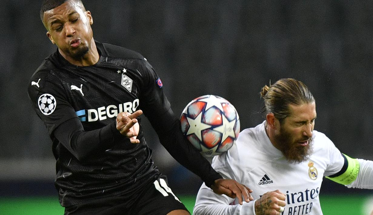 Bek Real Madrid, Sergio Ramos berebut bola dengan pemain Borussia Monchengladbach, Alassane Plea pada pertandingan grup B Liga Champions di  Borussia Park, Jerman, Selasa (27/10/2020). Madrid bermain imbang 2-2 atas Monchengladbach. (AP Photo/Martin Meissner)