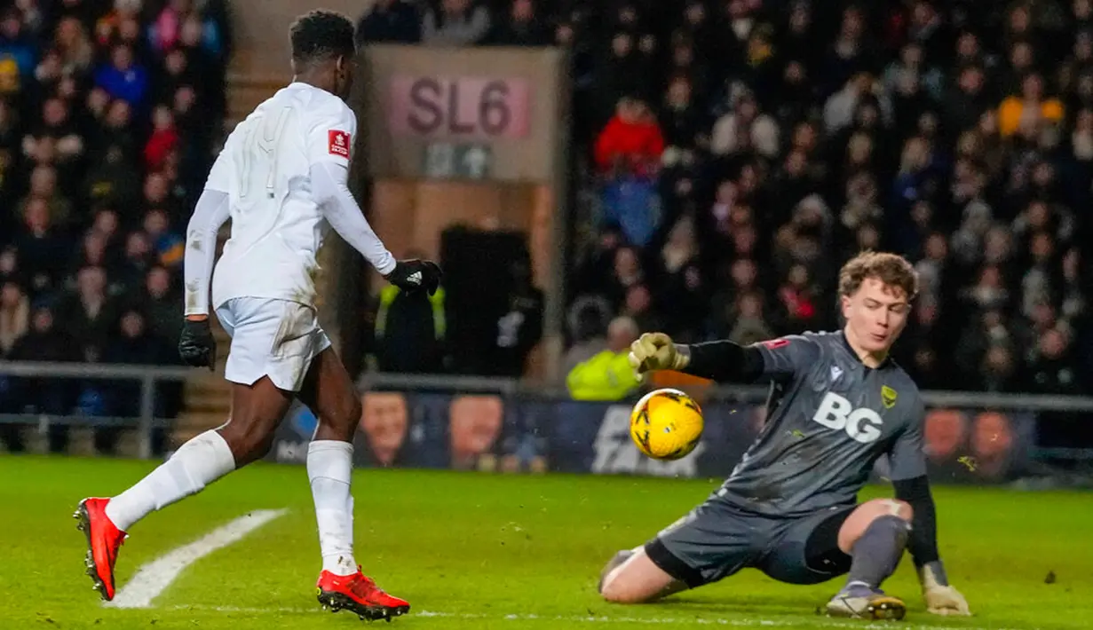 Pemain Arsenal Eddie Nketiah (kiri) mencetak gol ke gawang Oxford United yang dijaga kiper Edward McGinty pada pertandingan sepak bola Piala FA di Stadion Kassam, Oxford, Inggris, 9 Januari 2023. Arsenal menang 3-0. (AP Photo/Frank Augstein)