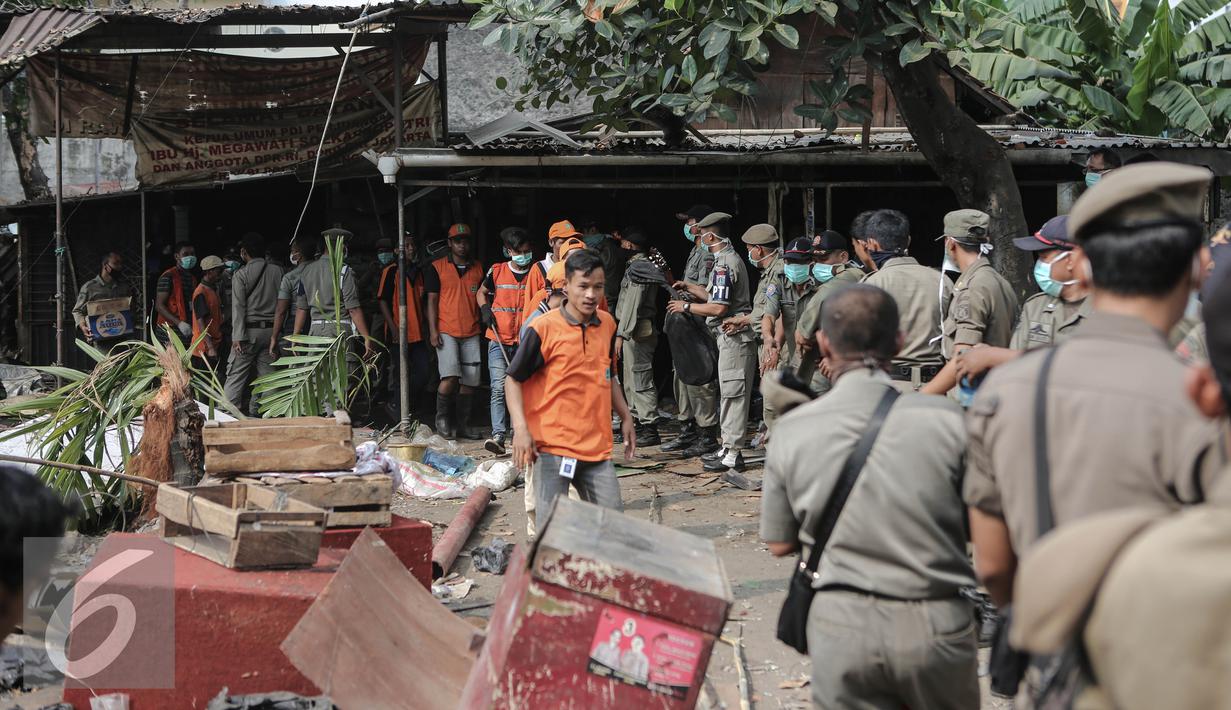 Petugas Satpol PP mengevakuasi barang milik penghuni saat penggusuran di Rawasari Selatan, Jakarta, Kamis (23/7/2015). Tampak upaya petugas saat melakukan pengusuran di  Rawasari Selatan. (Liputan6.com/Faizal Fanani)