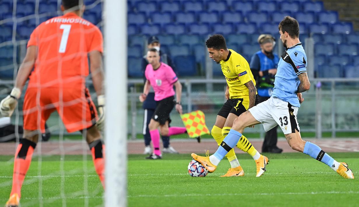 Bek Lazio, Francesco Acerbi, berebut bola dengan gelandang Borussia Dortmund, Jadon Sancho, pada laga Grup F Liga Champions 2020/2021 di Stadion Olimpico, Rabu (21/10/2020) dini hari WIB. Lazio menang 3-1 atas Borussia Dortmund. (AFP/Alberto Pizzoli)