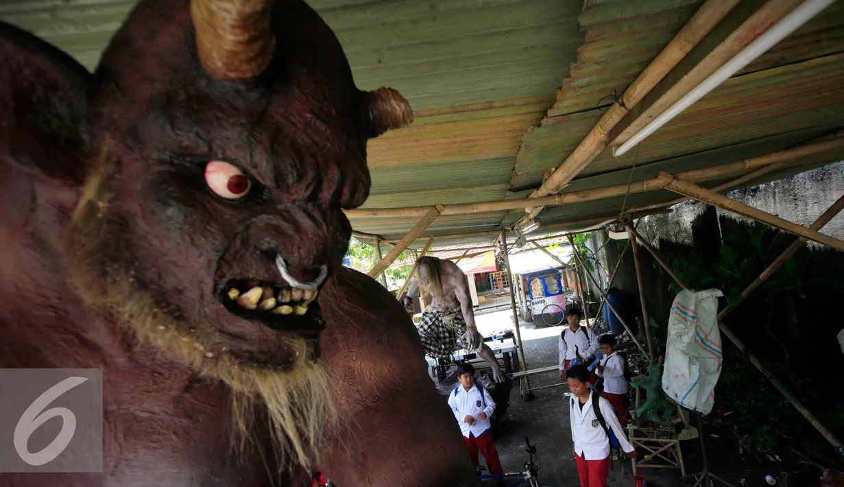 Sejumlah siswa menyaksikan Ogoh-ogoh yang akan di arak menjelang perayaan Nyepi di Pura Jagatnata,Yogyakarta, Senin (7/3/2016). Nyepi berasal dari kata sepi (sunyi, senyap). (Liputan6.com/Boy Harjanto)