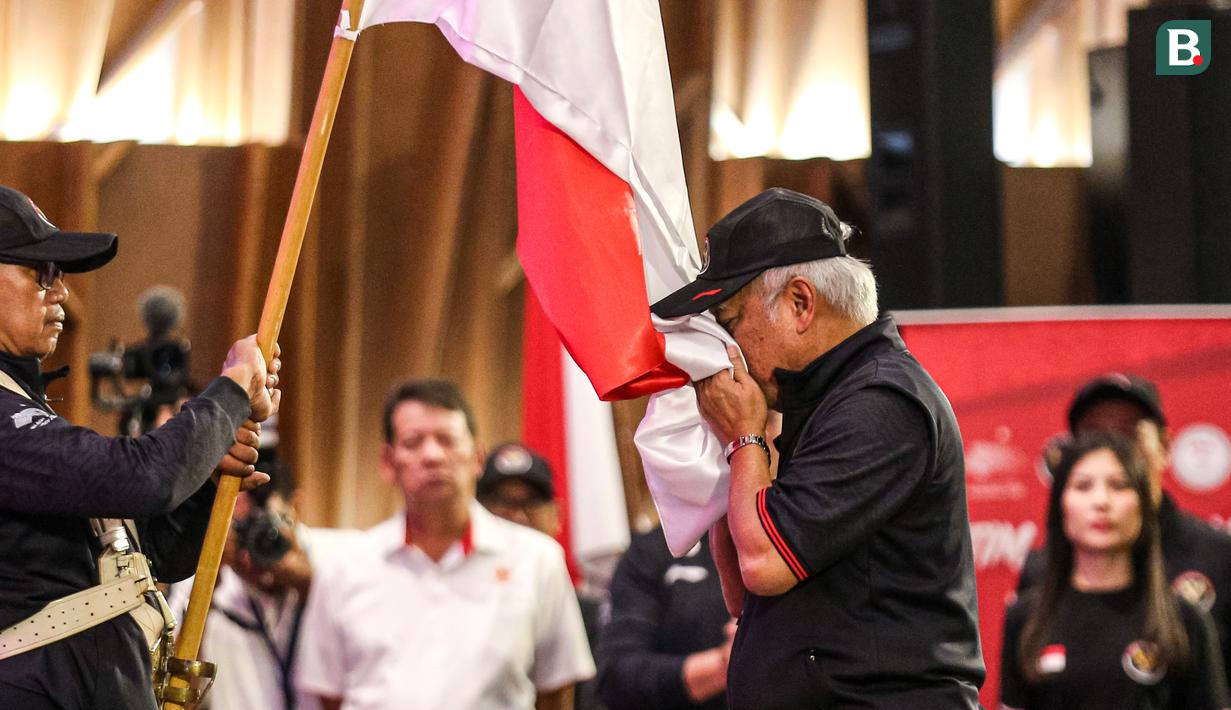 <p>Chef de Misson (CdM) Indonesia di Asian Games 2022, Basuki Hadimuljono mencium bendera merah putih saat pengukuhan Tim Indonesia untuk Asian Games 2022 Hangzhou di Auditorium Kementerian PUPR, Jakarta, Selasa (19/09/2023). (Bola.com/Bagaskara Lazuardi)</p>