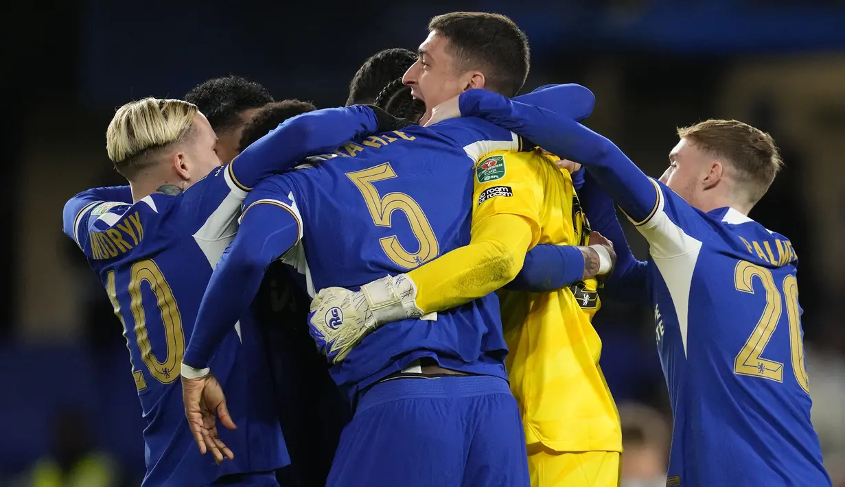 Para pemain Chelsea memeluk kiper Djordje Petrovic setelah berhasil memblok eksekusi penalti gelandang Newcastle United, Matt Ritchie saat adu tendangan penalti yang memastikan Chelsea menang 4-2 (1-1) pada laga perempatfinal Carabao Cup 2023/2024 di Stamford Bridge, London, Rabu (20/12/2023) dini hari WIB. (AP Photo/Kirsty Wigglesworth)