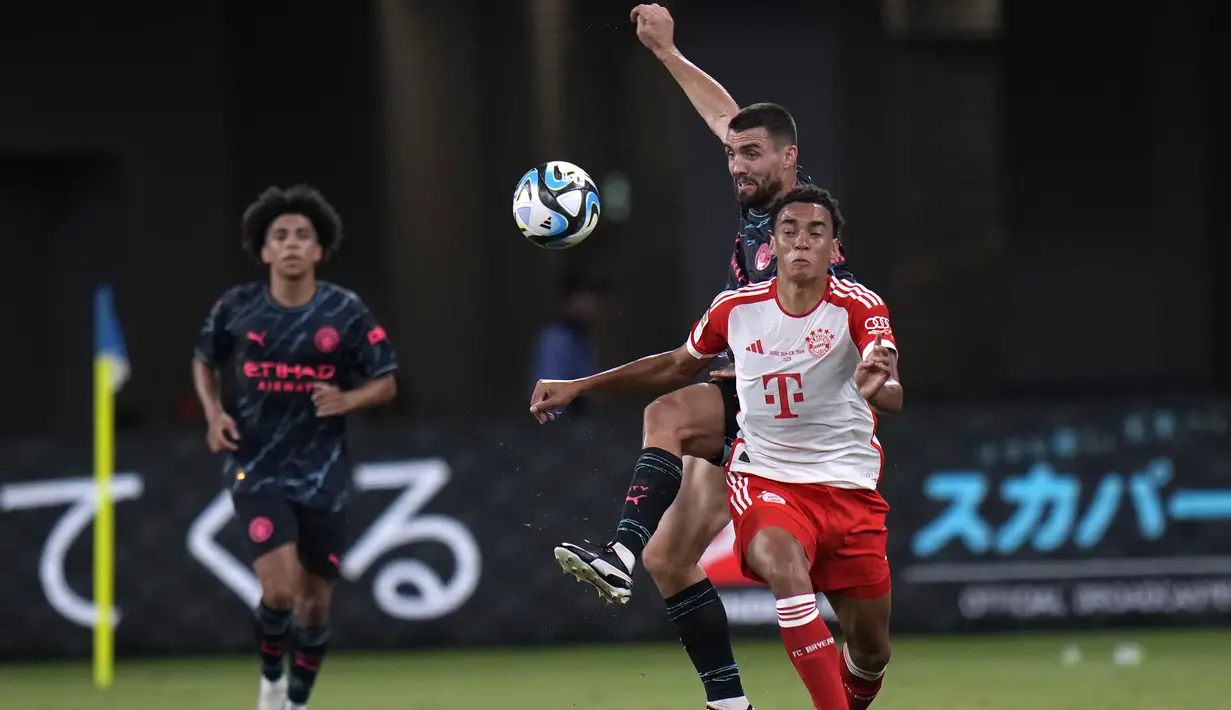Gelandang Bayern Munchen, Jamal Musiala (depan) berebut bola dengan gelandang Manchester City, Mateo Kovacic pada laga pramusim 2023/2024 bertajuk Audi Football Summit di Stadion Nasional Tokyo, Jepang, Rabu (26/7/2023) malam WIB. (AP Photo/Shuji Kajiyama)