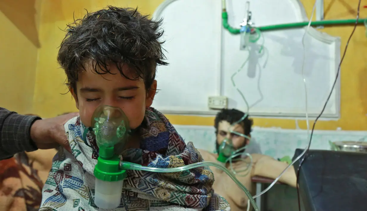 Seorang anak mendapat bantuan pernapasan usai menghirup senjata kimia di Al-Shifuniyah, Ghouta Timur, Damaskus, Suriah, Minggu (25/2). Kementerian Kesehatan Pemerintah Sementara Suriah menyebut, bau klorin tercium usai ledakan besar. (HAMZA AL-AJWEH/AFP)