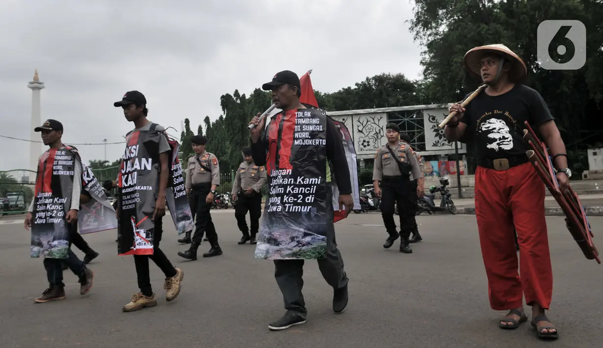 Tiga warga Mojokerto, Ahmad Yani (45), Sugiantoro (31), dan Heru Prasetiyo (24) bersama aktivis saat tiba di seberang Istana Negara, Jakarta, Kamis (6/2/2020). Mereka berjalan kaki dari Mojokerto meminta pemerintah menghentikan aktivitas penambangan di Sungai Woro. (merdeka.com/Iqbal S Nugroho)