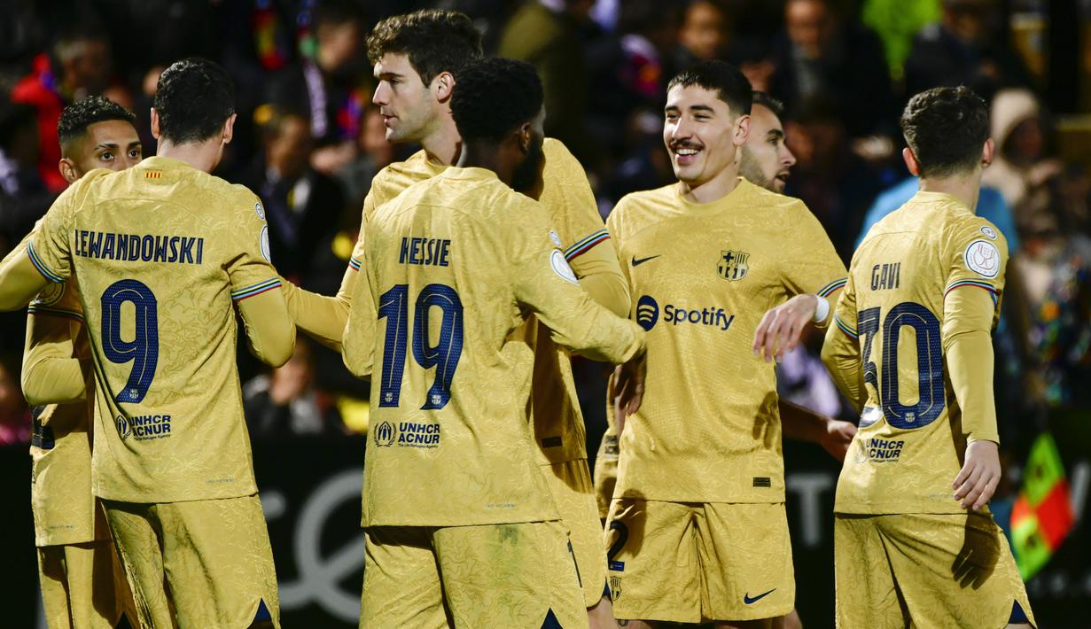 Pemain Barcelona merayakan kemenangan atas Ceuta pada laga Copa del Rey di Stadion Alfonso Murube (19/1/2023). Robert Lewandowski menjadi bintang. Ia mampu membukukan brace atau dua gol. Adapun tiga gol Barcelona lainnya disumbangkan oleh Raphinha, Ansu Fati, Franck Kessie. (AP Photo/Antonio Sempere)