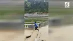 Seorang pria membuat ulah di Kuil Xitian, Dehua, China, dengan mendorong seekor monyet ke kolam.