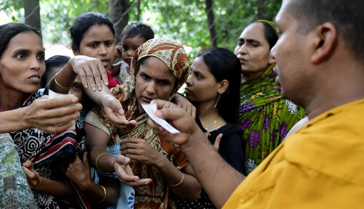 Seorang biksu membagikan kupon untuk mendapatkan iftar (makanan berbuka puasa) kepada umat muslim di Wihara Dhammarajika, Dhaka, Bangladesh, Selasa (7/7). Ini merupakan momen langka keharmonisan umat beragama di negara Asia. (AFP PHOTO/Munir uz ZAMAN)