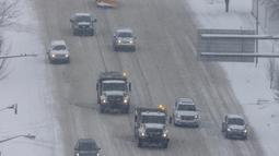 Kendaraan bajak salju melintas dari West Michigan Avenue di pusat kota Kalamazoo, Michigan, Rabu (2/2/2022). Gubernur mendesak penduduk untuk menjauh dari jalan dan menutup sekolah dan kampus. (Joel Bissell/Kalamazoo Gazette via AP)