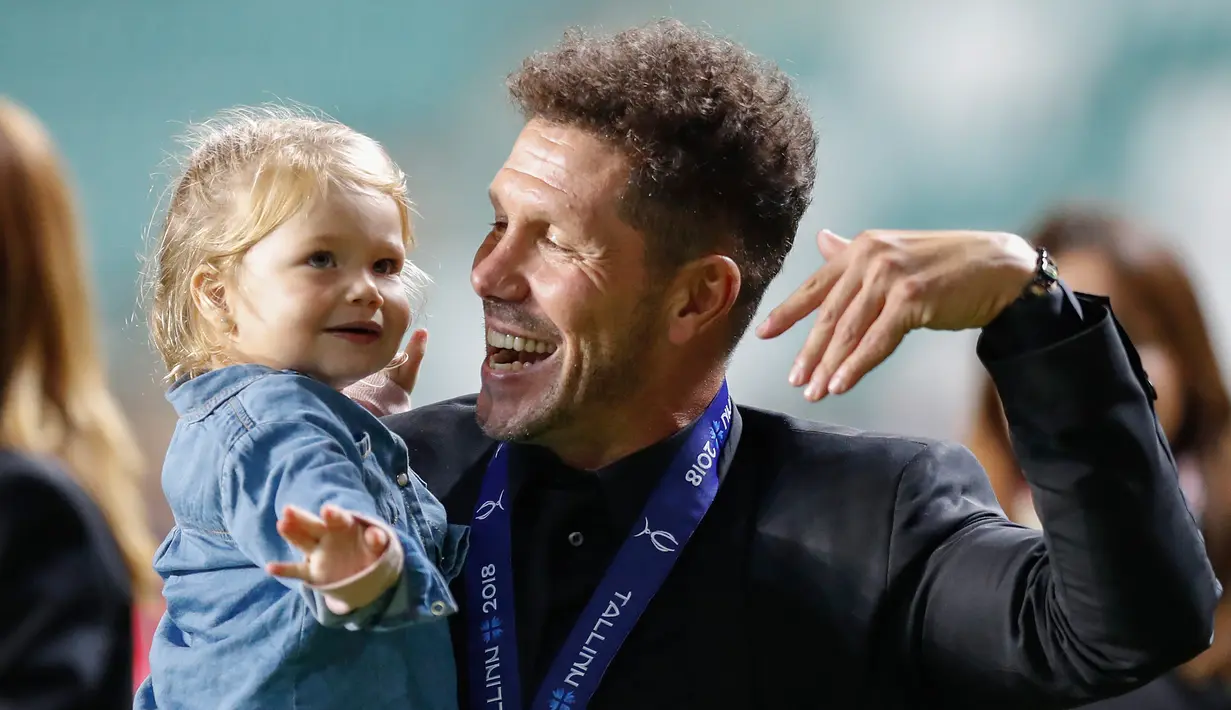Pelatih Atletico Madrid, Diego Simeone tersenyum bersama putrinya Francesca saat berselebrasi meraih juara Piala Super Eropa setelah mengalahkan Real Madrid 4-2 di Lillekula Stadium di Tallinn, Estonia, (15/8). (AP Photo/Pavel Golovkin)