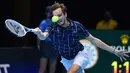 Petenis Rusia, Daniil Medvedev, mengembalikan bola ke arah lawannya, petenis Austria, Dominic Thiem dalam partai final tunggal putra Turnamen Tenis ATP Finals 2020 di O2 Arena, London, Inggris, Minggu (22/11/2020). Daniil Medvedev menang dengan skor 4-6, 7-6 (2), 6-4. (AFP/Glyn Kirk)