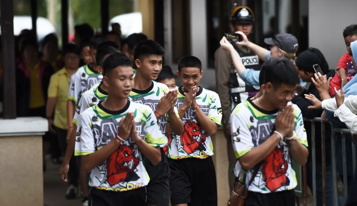 12 anak laki-laki dan pelatih sepak bola mereka, yang diselamatkan dari gua banjir di Thailand tiba menghadiri konferensi pers di Chiang Rai, Rabu (18/7). Mereka muncul di depan umum untuk pertama kalinya sejak keluar dari RS. (LILLIAN SUWANRUMPHA /AFP)
