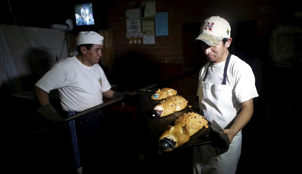 Dua orang pria saat membawa Roti Tantawawas untuk ikut merayakan peringatan All Saints di La Paz, Bolivia, Rabu (28/10/2015).  Mereka percaya bahwa jika semua persembahan ini nanti akan membahagiakan para leluhur mereka.  (REUTERS/David Mercadoâ)