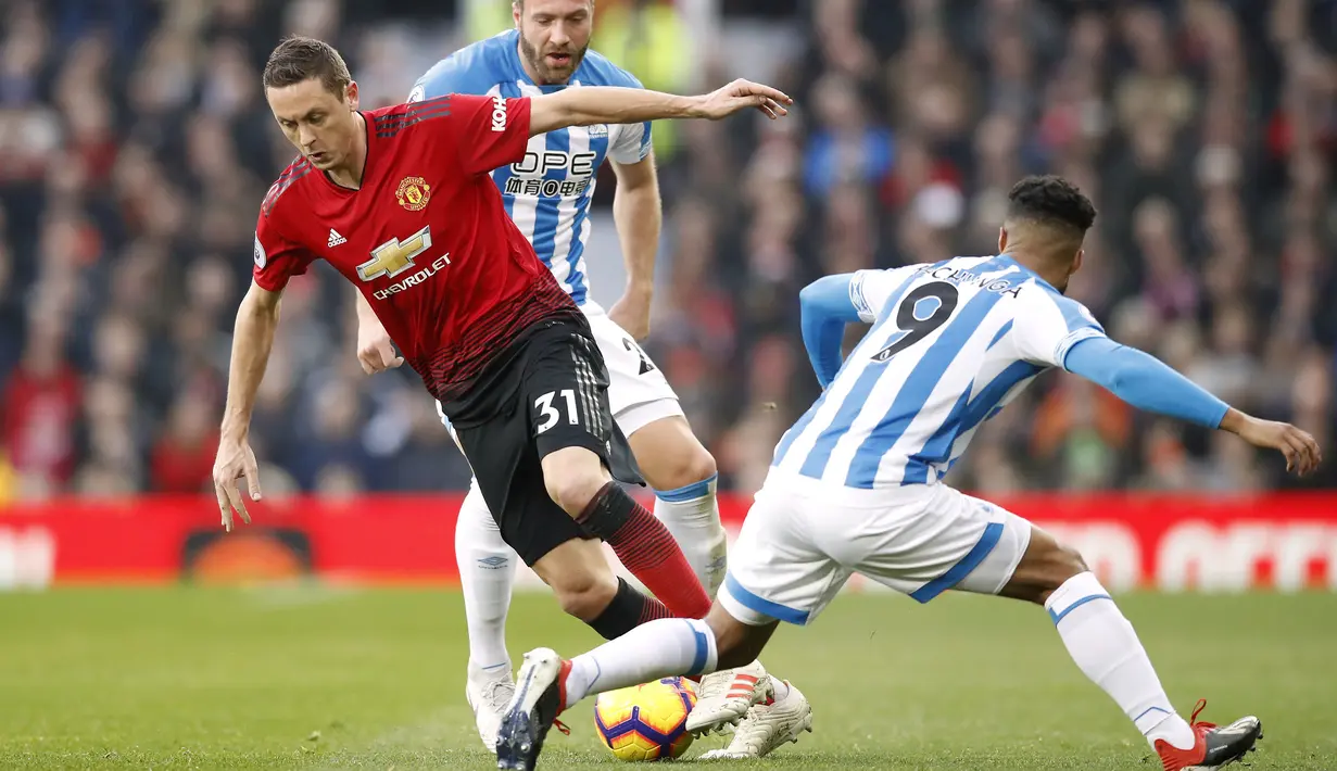Gelandang Manchester United, Nemanja Matic, berusaha melewati pemain Huddersfield pada laga Premier League di Stadion Old Trafford, Rabu (26/12). Manchester United menang 3-1 atas Huddersfield. (AP/Martin Rickett)