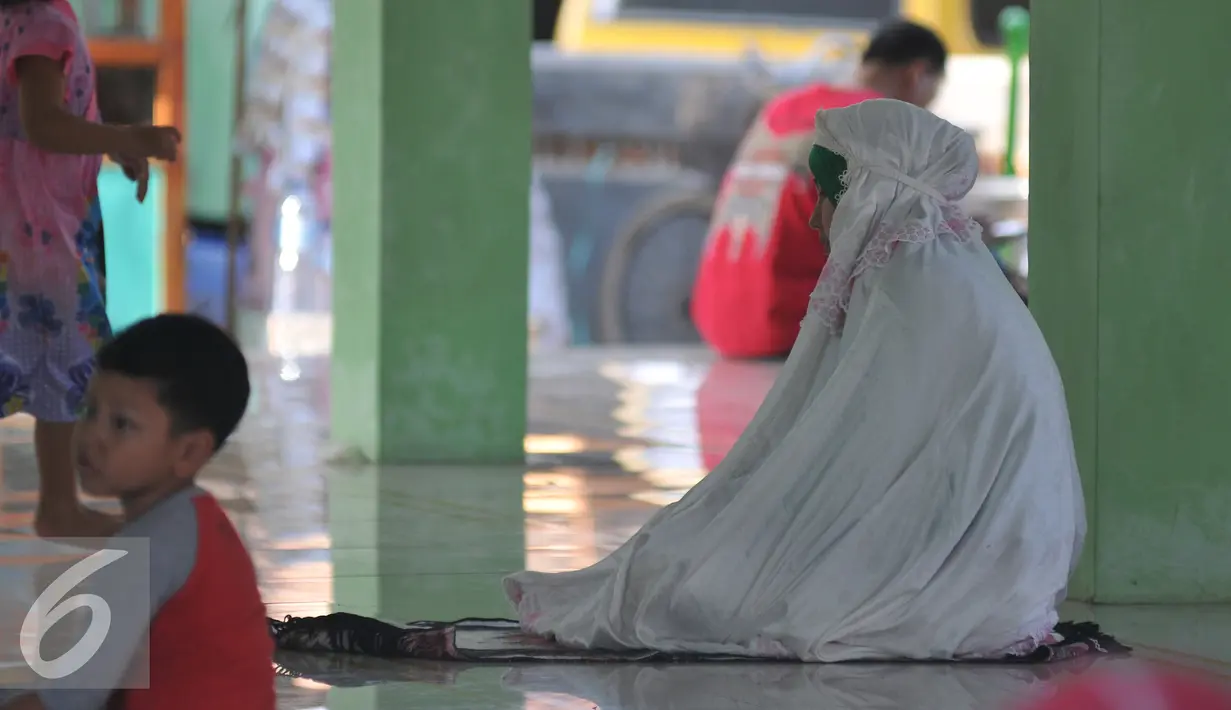 Pemudik melakukan ibadah saat berhenti di sebuah mesjid di kawasan Arjawinangun, Cirebon, Jawa Barat, Rabu (15/7/2015). Banyak pemudik melakukan aktivitas seperti salat, mengaji, tidur dll di mesjid tersebut. (Liputan6.com/Herman Zakharia)