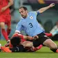 Bek Uruguay Diego Godin menghentikan striker Korea Selatan Hwang Ui-jo pada laga Grup H Piala Dunia 2022 di Education City Stadium, Kamis (24/11/2022). (AP Photo/Frank Augstein)