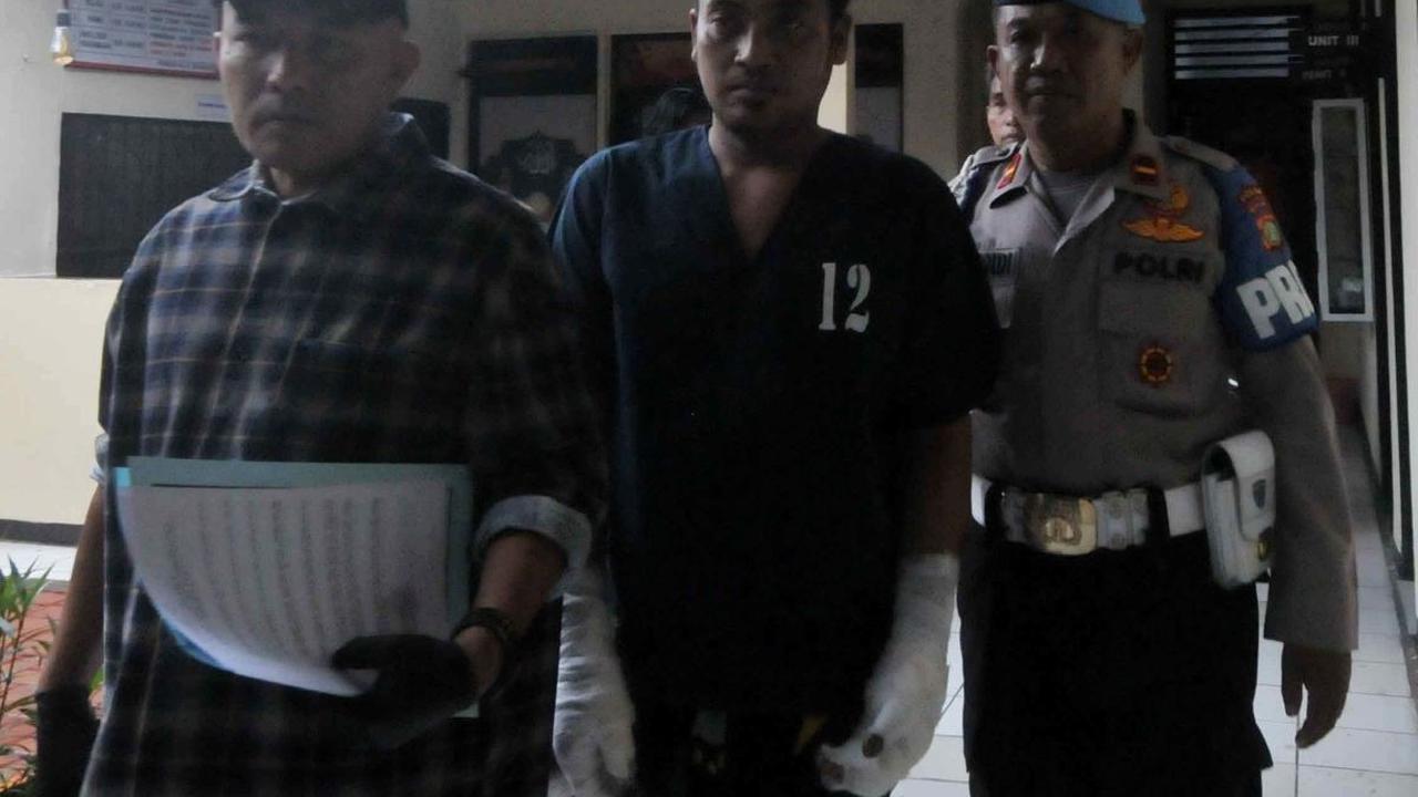 Tersangka EST (34) digelandang petugas untuk dihadirkan dalam rilis kasus penganiayaan di Mapolsek Pasar Rebo, Jakarta Timur, Selasa (25/6/2024). EST, joki permainan tong setan, ditangkap setelah membakar hidup-hidup rekannya, AMG (31), yang merupakan tuy