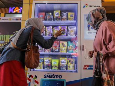 Calon penumpang kereta melakukan transaksi pembelian melalui vending machine BUMN untuk UMKM di Stasiun Gondangdia, Jakarta, Senin (22/1/2024). (Liputan6.com/Angga Yuniar)