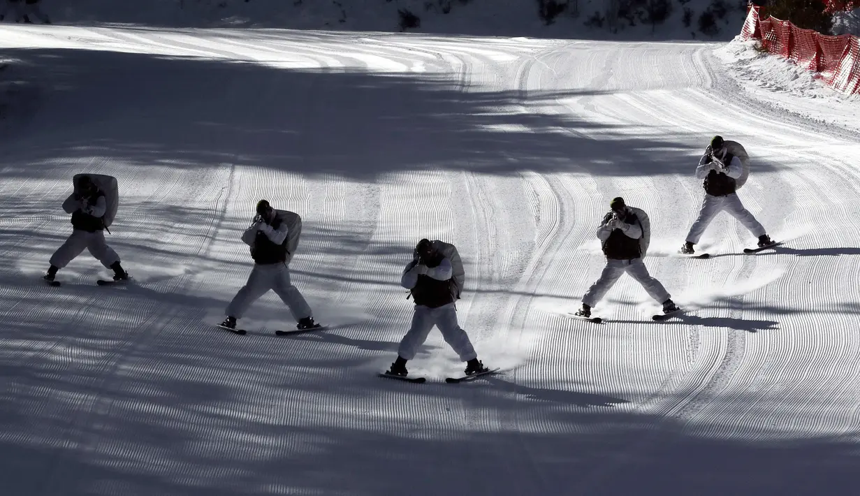 Gabungan tentara Korea Selatan dan AS meluncur diatas salju sambil membidikan senjatanya saat latihan musim dingin di Pyeongchang, Korea Selatan (24/1). (AP Photo/Lee Jin-man)