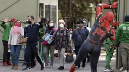Seorang pria yang mengenakan kostum Spiderman menyapa orang-orang setelah mereka disuntik vaksin covid-19 Pfizer-BioNTech di Mexico City, Meksiko, Selasa (28/12/2021). Spiderman tersebut dipekerjakan oleh Pemerintah Kota untuk menghibur para peserta vaksinasi. (ALFREDO ESTRELLA / AFP)
