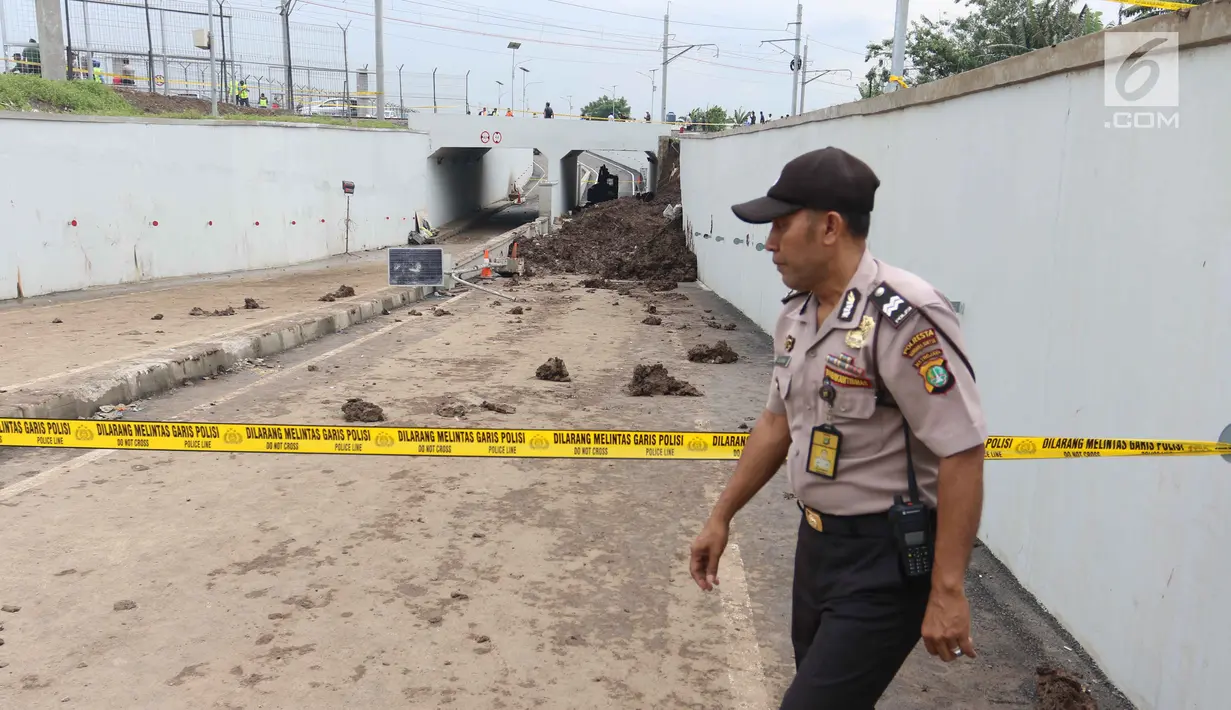 Petugas polisi berjaga di lokasi terjadinya underpass Perimeter Bandara Soekarno-Hatta, Cengkareng (6/2). Dari 2 korban, salah satu karyawan yang bernama Dianti Diah Ayu Cahyani Putri dinyatakan meninggal usai evakuasi. (Liputan6.com/Angga Yuniar)