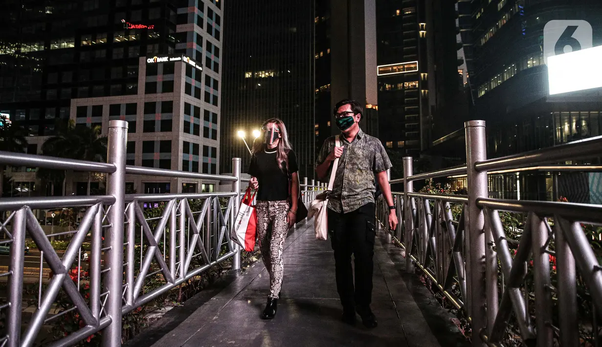 Warga berada di atas Jembatan Penyeberangan Orang (JPO) di Kawasan Sudirman, Jakarta, Kamis (24/9/2020). Pemprov DKI Jakarta kembali memperpanjang Pembatasan Sosial Berskala Besar (PSBB) hingga 11 Oktober untuk menekan laju penyebaran kasus covid-19. (Liputan6.com/Faizal Fanani)