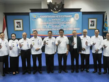 Kepala BNN, Budi Waseso (Buwas) beserta Menteri PANRB, Asman Abnur dan sejumlah stafnya berfoto bersama usai melakukan penandatanganan Nota Kesepahaman di Kantor BNN, Cawang, Jakarta, Senin (8/5). (Liputan6.com/Yoppy Renato)