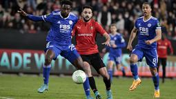 Penyerang Rennes Gaetan Laborde (tengah) berebut bola dengan bek Leicester City Ryan Bertrand pada leg kedua babak 16 besar Europa Conference League di Roazhon Park , Jumat (18/3/2022) dini hari WIB. Meski kalah 1-2, Leicester City tetap lolos ke perempat final. (AP Photo/Jeremias Gonzalez)