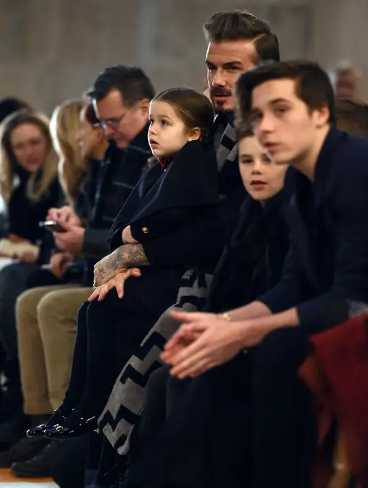 David Beckham terlihat serius mengamati koleksi busana terbaru milik sang istri Victoria Beckham Fall/Winter 2016 bersama anak-anaknya Harper, Cruz, Romeo dan Brooklyn di New York Fashion Week (14/2). (AFP/Jewel Samad)