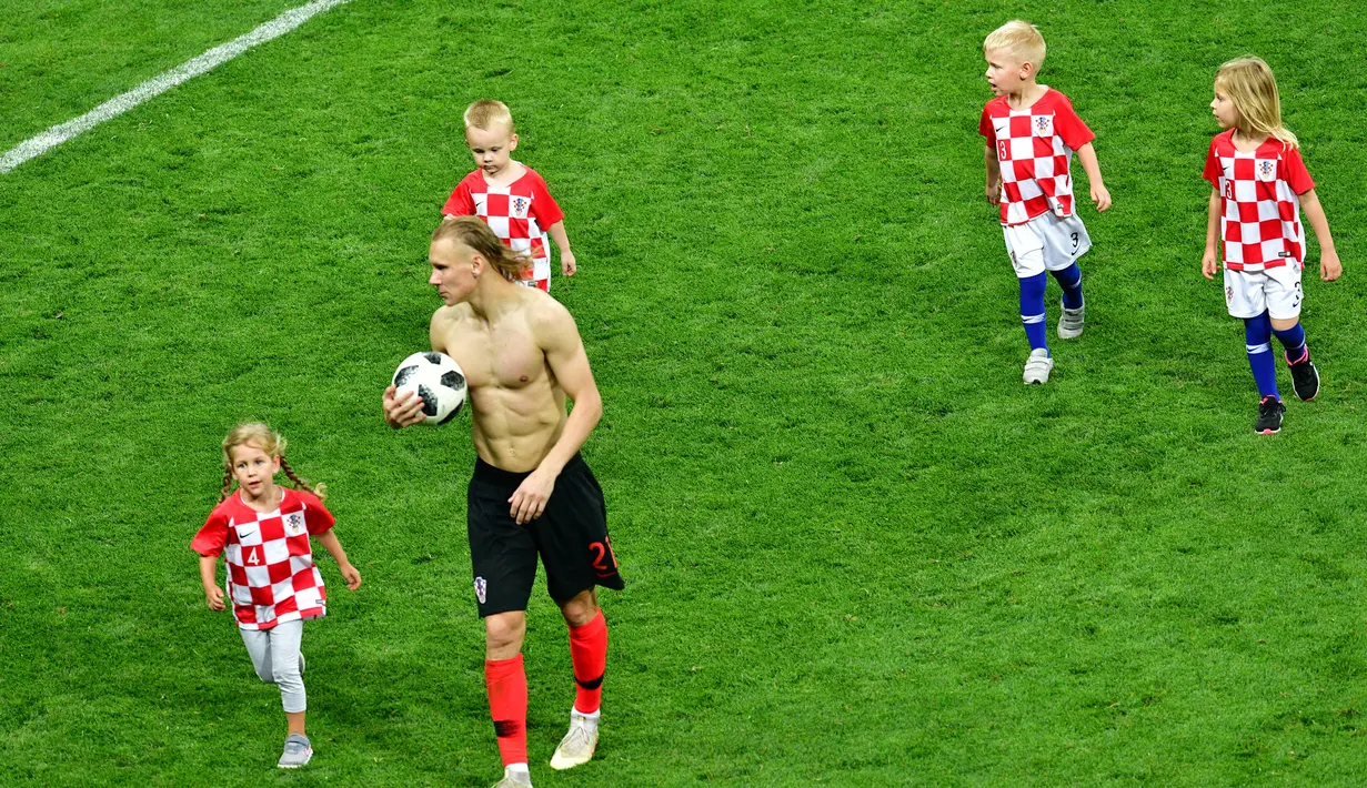 Bek Kroasia, Domagoj Vida bersama anak-anak pemain Kroasia berjalan di lapangan usai menundukkan Inggris di laga semifinal Piala Dunia 2018 di Stadion Luzhniki, Moskow, Rusia, Rabu (11/7). (MLADEN ANTONOV/AFP)