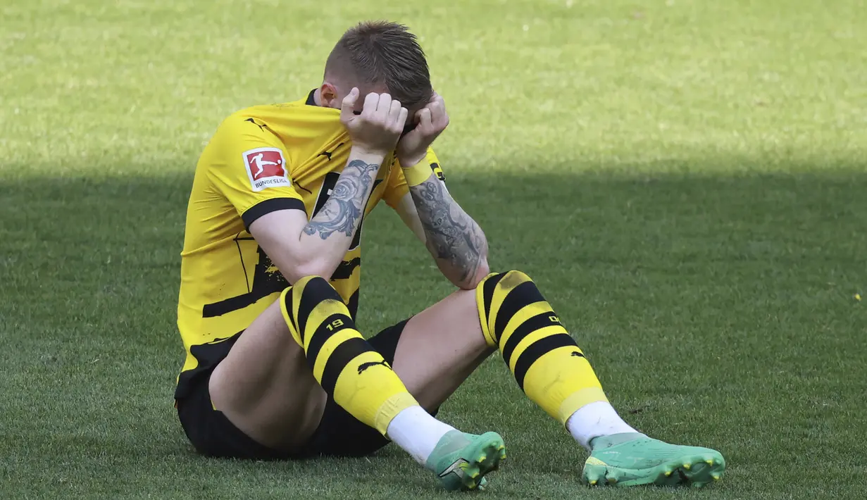 Striker Borussia Dortmund, Marco Reus terduduk sambil menutupi wajahnya setelah berakhirnya laga menghadapi FSV Mainz pada laga pekan terakhir Liga Jerman 2022/2023 di Dortmund, Jerman (27/5/2023). Ditahan imbang FSV Mainz 2-2, Borussia Dortmund harus merelakan gelar juara Liga Jerman 2022/2023 menjadi milik Bayern Munchen. (AP Photo/Michael Probst)