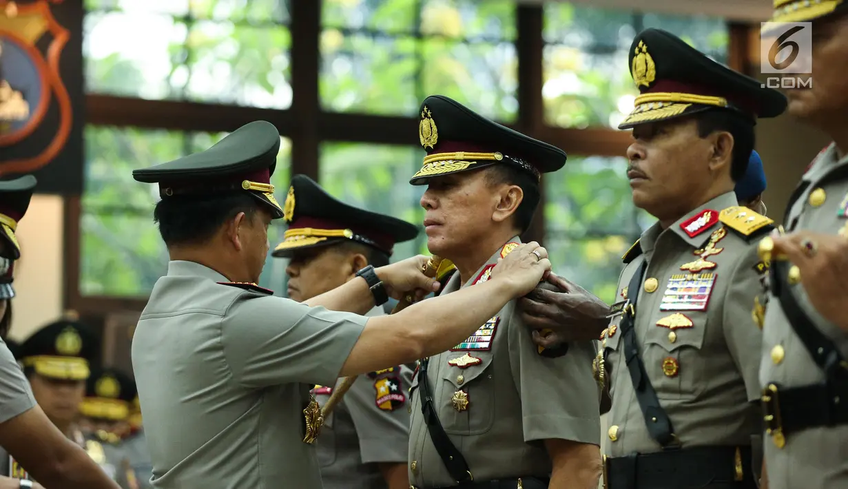Kapolri Jenderal Tito Karnavian memasangkan tanda pangkat pada Irjen Mochamad Iriawan saat acara sertijab di Rupatama Mabes Polri, Rabu (26/7). Jabatan Iriawan sebagai Kapolda Metro Jaya digantikan oleh Irjen Idham Aziz. (Liputan6.com/Faizal Fanani)