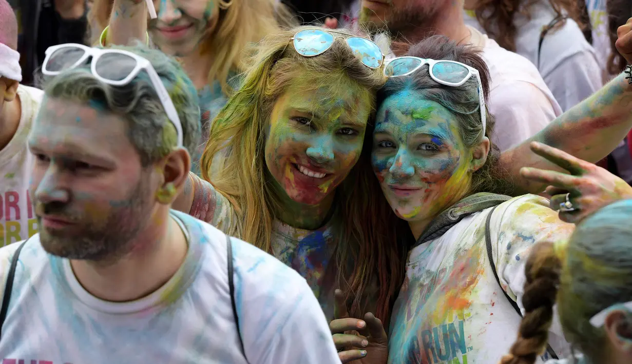 Peserta berpose saat acara Color Run 2017 di depan Menara Eiffel, Paris, Minggu (16/4). Peserta yang hadir diperkirakan mencapai 35ribu orang. (AFP PHOTO / CHRISTOPHE ARCHAMBAULT)