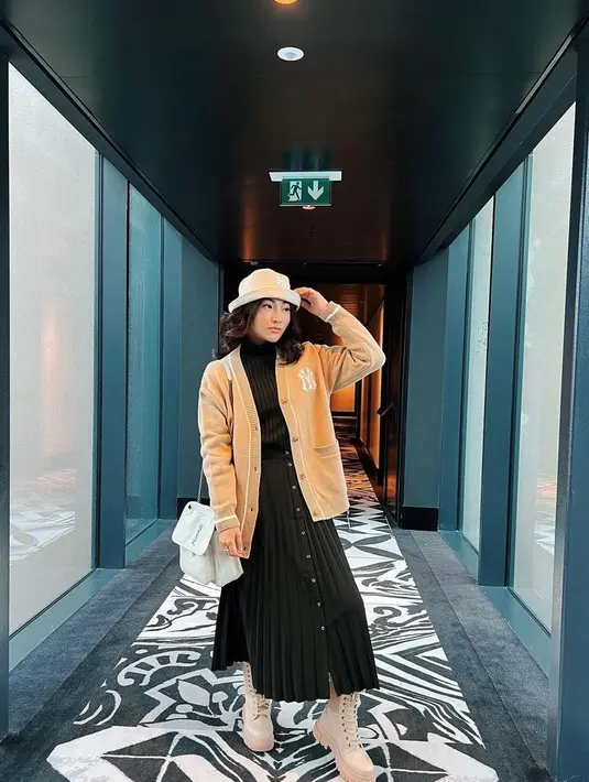 Pada OOTD berikutnya, Sarwendah memadukan t-shirt dan rok plisket warna hitam dengan cardigan dan topi berwarna cokelat. Gaya modisnya pun disempurnakan dengan sepatu boots warna krem. (Instagram/sarwendah29).